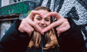 Mädchen formt mit Händen ein Herz.